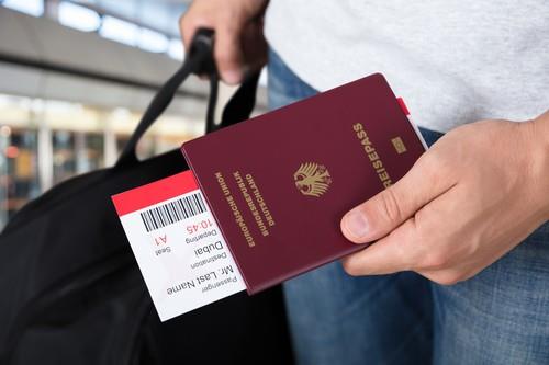 Čovek nosi pasoš sa kartom i ručni prtljag