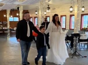 Mlada i mladoženja ulaze u salu sa sinom