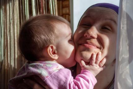 Mama uživa dok je njena beba ljubi