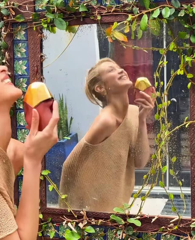 Bela Hadid u zlatnom poluprovidnom šalu i gingham pantalonama promoviše parfem Eternal Roots