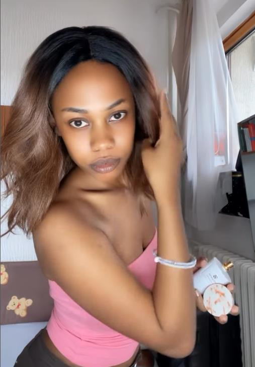 Džulijan Abasa se ogleda i isprobava parfem.jpg