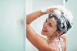 stockphotosmilingyoungwomanwashingheadwithshampoo128732432.jpg