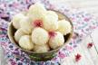 stockphotohomemadecoconutballsdecoratedwithlittlepinkflowersinmetalbowlwoodenbackground137139851.jpg