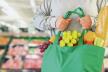 stockphotocustomerholdreusablegreenshoppingbagwithfruitandvegetableoversupermarketaisleblur1257013726.jpg