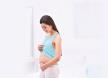 stockphotobeautifulpregnantwomantouchingherbellystandinginlightroom604597088.jpg