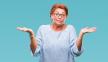 stockphotoatrractiveseniorcaucasianredheadwomanwearingglassesoverisolatedbackgroundcluelessand1242294583.jpg