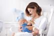 stockphotoyoungmotherholdinghernewbornchildmomnursingbabywomanandnewbornboyinwhitebedroom388644496.jpg