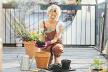 stockphotolovelywomaninbrownoverallsreplantingflowersatterraceoutdoorrelaxingafterworkingday1808720428.jpg