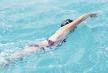 stockphotoyounggirlingogglesandcapswimmingfrontcrawlstrokestyleinthebluewaterpool257784676.jpg