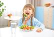 stockphotosmallgirleatingvegetablesinkitchen562272967.jpg