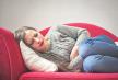 stockphotoyounggirlwithstomachpainlyingonthesofa581614936.jpg