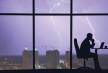 stockphotothemanworkingatthetablenearawindowonacitylightningbackground1460333147.jpg