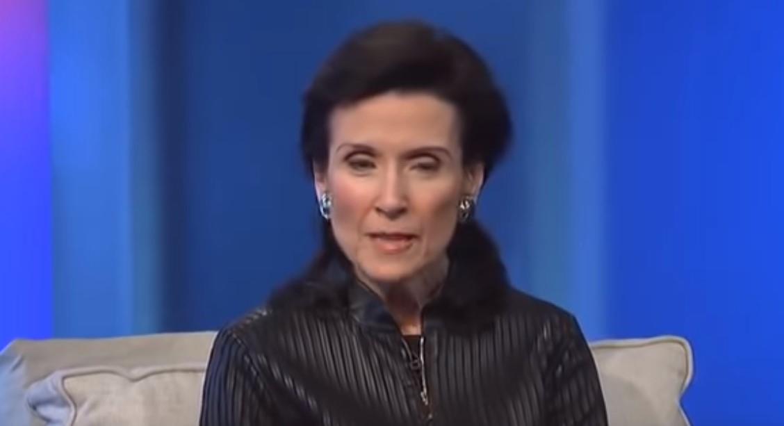 Merilin vos Savant u crnoj košulji sedi na krevetu naslonjena na jastuk