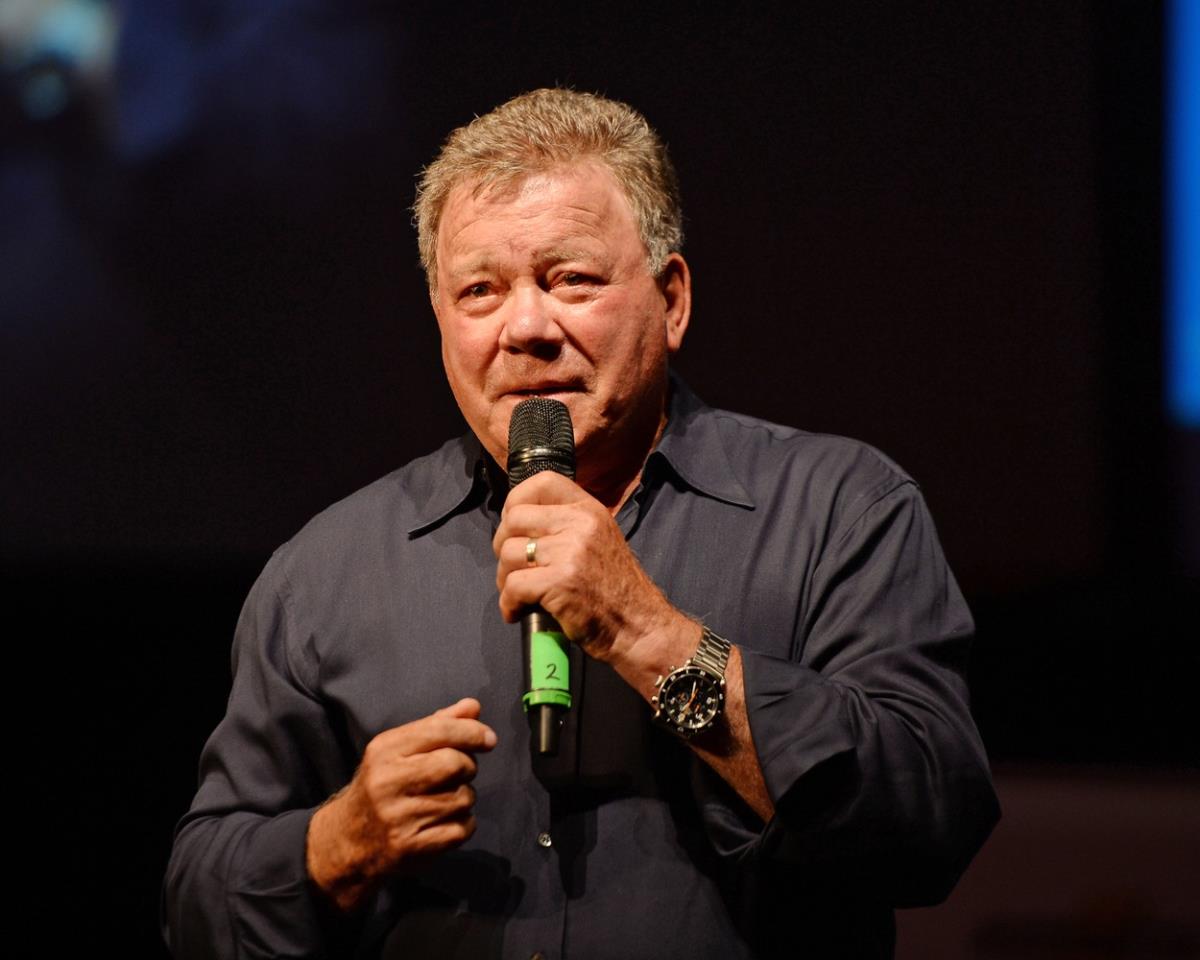 Vilijam Šatner u sivoj košulji drži govor