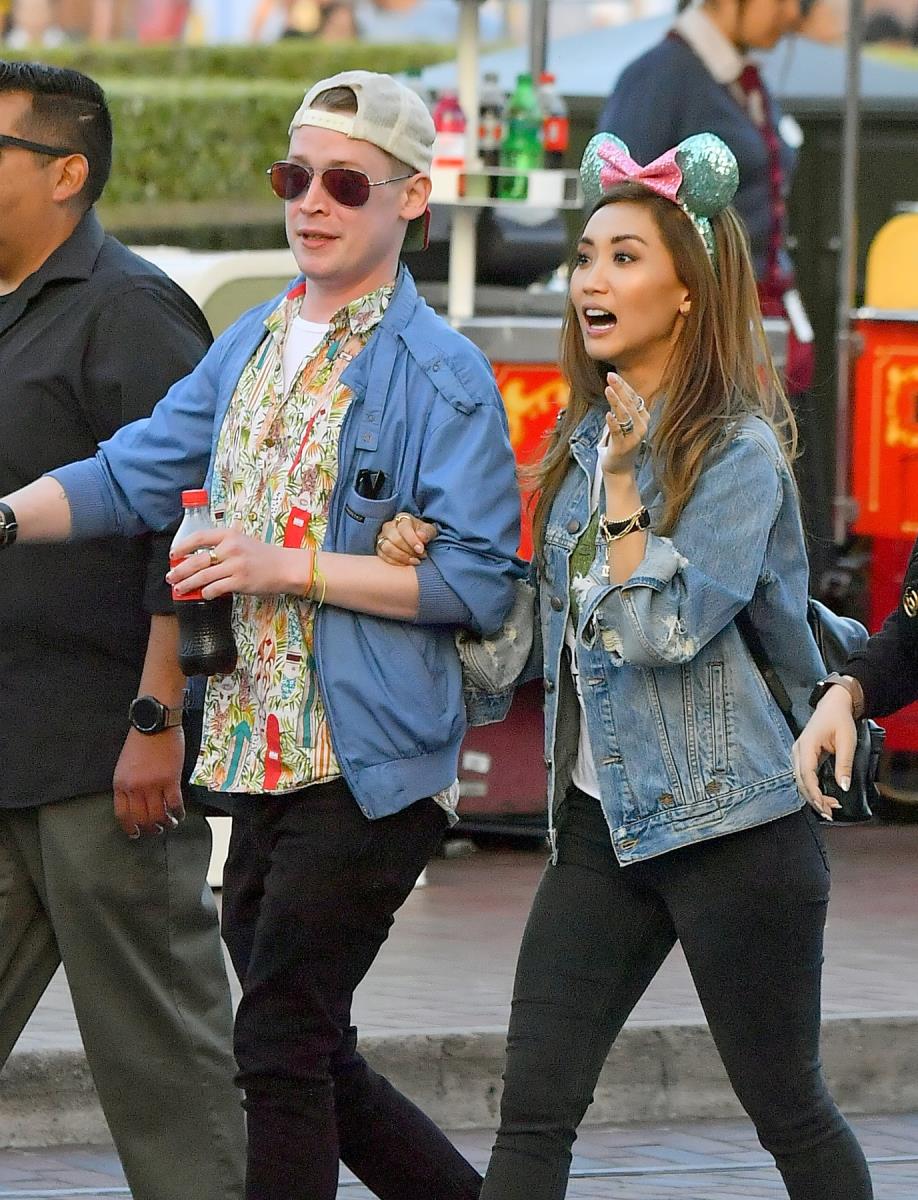 Mekoli Kalkin i Brenda Song u voznom parku šetaju ulicom