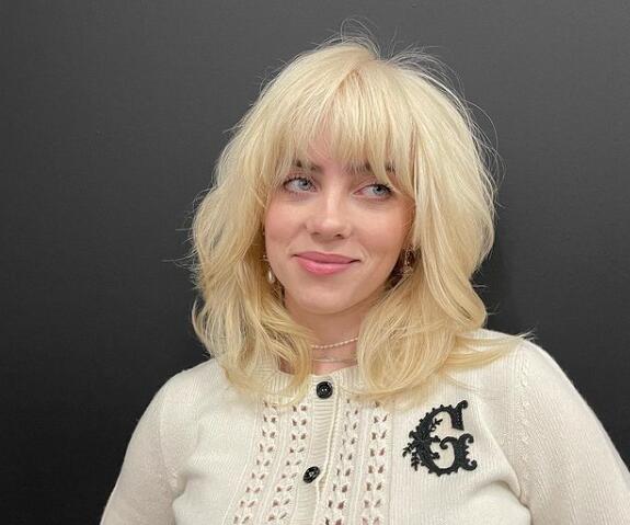 Bili Ajliš kao plavuša u belom džemperu