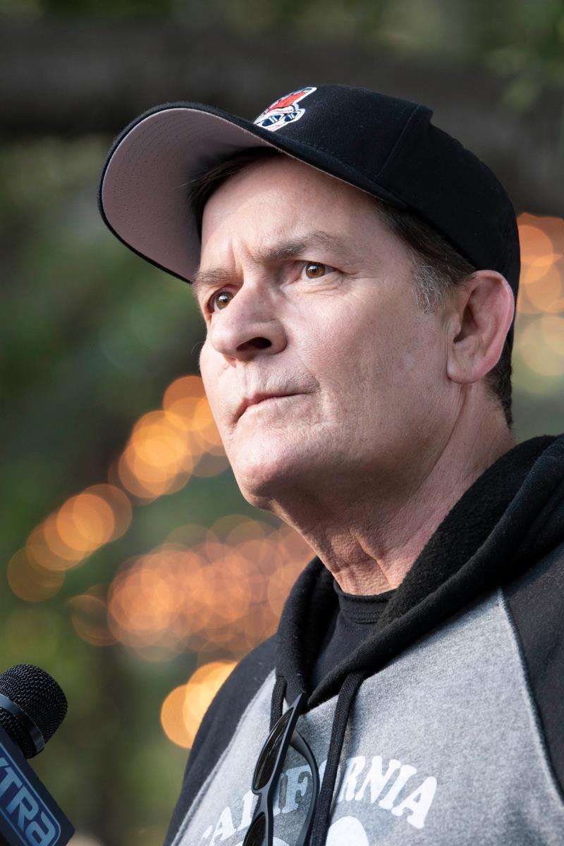 Čarli Šin u duksu sa kačketom na glavi