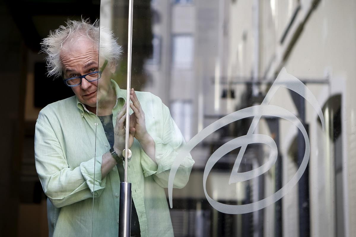 Ivan Tasovac viri iza staklenih vrata sa naočarima na glavi