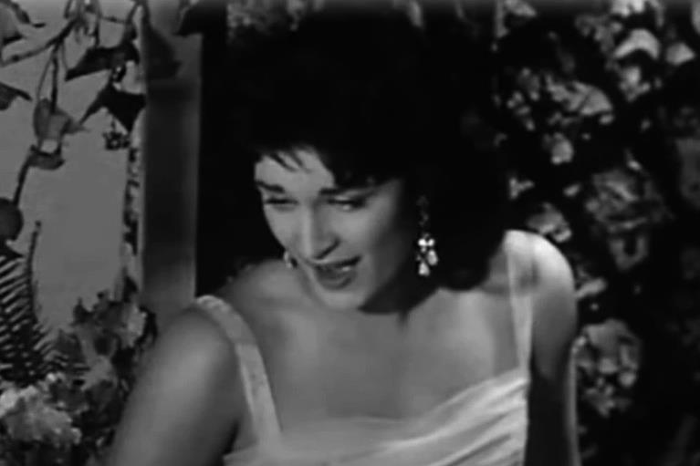 Jolanda Điljoti Dalida u beloj haljini sa crnom kosom, peva