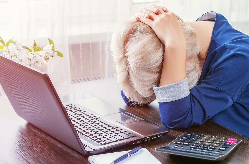 Žena se drži za ispred laptopa