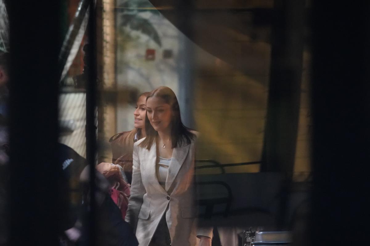 Aleksandra Prijović u bež sakou i beloj majici, nasmejana hoda u društvu žene