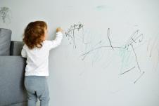 stockphotocurlycutelittlebabygirldrawingwithcrayoncoloronthewallworksofchild373556938.jpg