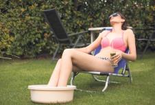 stockphotoyoungwomaninabikinienjoyinginthebackyardwithherfeetinawashbowl1120010615.jpg