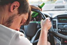 stockphotodrunkyoungmandrivingacarwithabottleofbeerdontdrinkanddriveconceptdrivingunder556554751.jpg