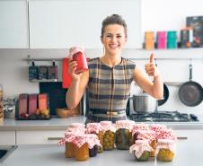 stockphotoportraitofhappyyounghousewifeamongjarswithhomemadefruitsjamandpickledvegetables257211397.jpg