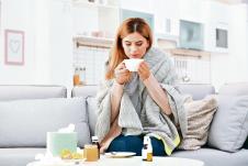 stockphotowomanwithcupofteaforcoughonsofaathome1225035835.jpg