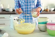 stockphotoyoungwomanmakingrainbowcakeinkitchen323463362.jpg