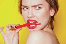 stockphotoyoungsexywomanbitingachilipepperonyellowbackground1071434765.jpg