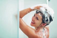 stockphotosmilingyoungwomanwashingheadwithshampoo128732432.jpg