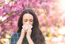 stockphotoyoungprettygirlblowingnoseinfrontofbloomingtreespringallergyconcept1084394462.jpg