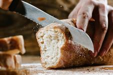 stockphotowholegrainbreadputonkitchenwoodplatewithachefholdinggoldknifeforcutfreshbreadon1023191101.jpg