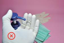 stockphotohandinmedicalglovesusingantibacterialsanitizerconceptofhygienepreventofbacteriaand1690675204.jpg