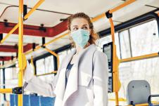 0210-stockphotowomanwearingsurgicalprotectivemaskpushingthebuttoninapublictransportation1689657196.jpg