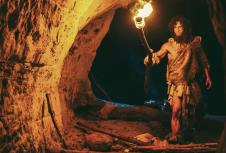 0808stockphotoprimevalcavemanwearinganimalskinexploringcaveatnightholdingtorchwithfirelookingat1595983396.jpg