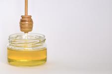 stockphotoglassjarwithhoneyandawoodenstickonawhitebackgroundpouringaromatichoneyintojar1655874790.jpg