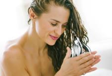 stockphotohappyyoungwomanapplyinghairconditionerinbathtub674437357.jpg