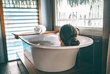 stockphotobathtakingwomanrelaxinginbathtubofhotelroomatluxuryoverwaterbungalowresortinbora1655026558.jpg