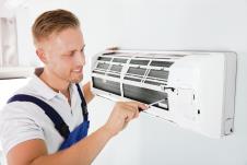 stockphotohappymaletechnicianrepairingairconditionerwithscrewdriver555972346.jpg