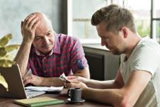 stockphotosadandstressedelderlyfatherandhisadultsoncountingmoneyhavetroubleswithtaxesanddebts1508074568.jpg