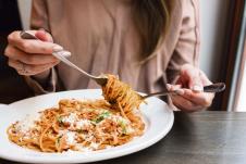 stockphotogirleatsitalianpastawithtomatomeatcloseupspaghettibolognesewinditaroundaforkwith648087823.jpg