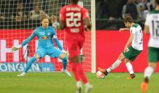 Fudbaler šutira loptu na go, golman brani