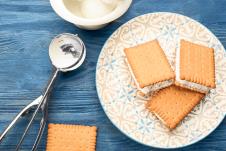 stockphotosweetdeliciousicecreamcookiesandwichesservedonbluewoodentableflatlay1596564766.jpg