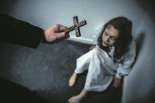 stockphotoexorcistholdingcrossinfrontofobsessedgirl1658730559.jpg