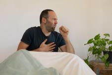 Muškarac kašlje i drži se za grudi