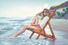 0608-stockphotoprettywomanrelaxingonaloungerbeachanddrinkssodawatersummervacationconcept1932700388.jpg