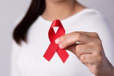 0801-stockphotocloseupwomanhandholdingredribbonhivworldaidsdayawarenessribbonhealthcareandmedicine2075934793.jpg